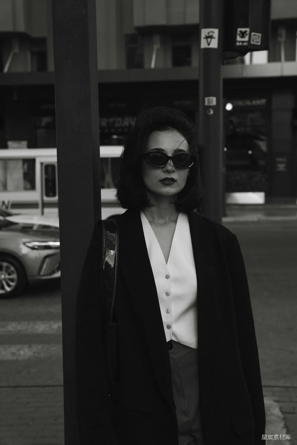 高清摄影 一个女人站在路边靠近一根电线杆。