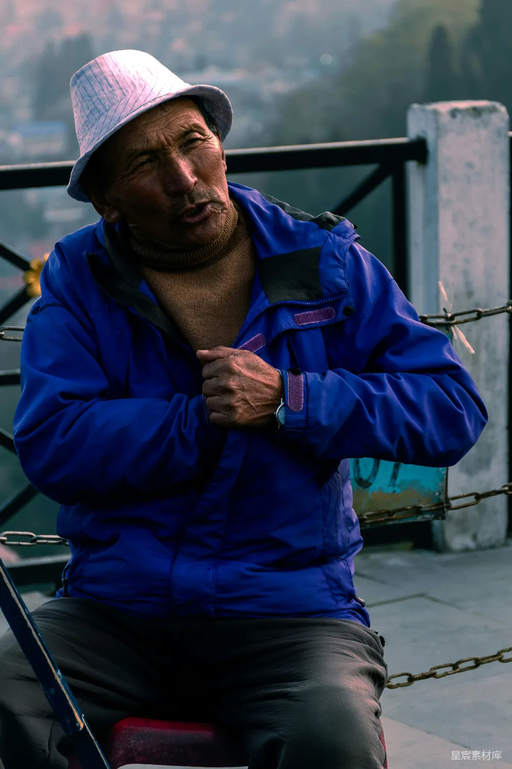 高清摄影 一个男人坐在长凳上，拿着鱼竿