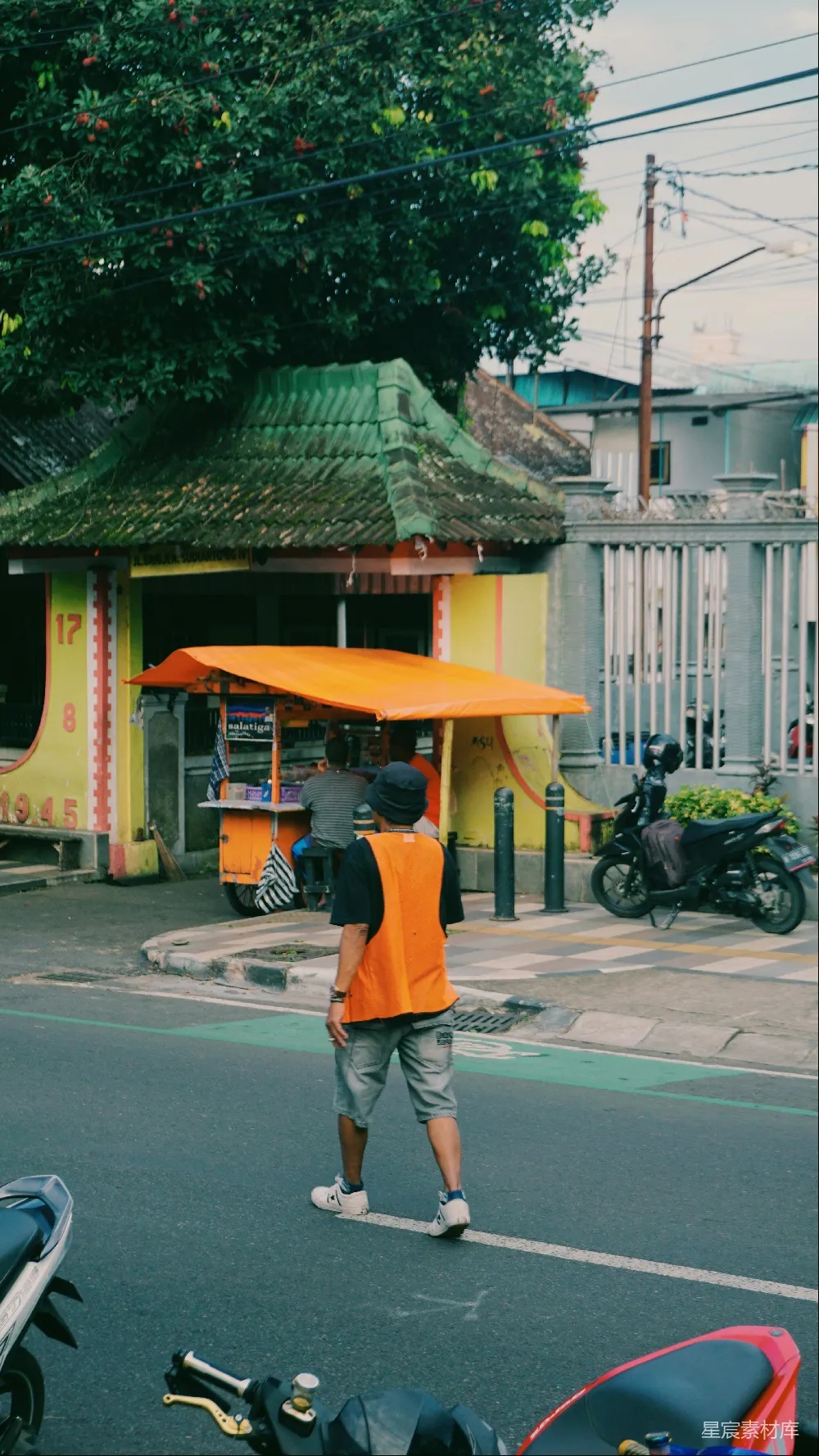 高清摄影 橙色背心的男人走在街上