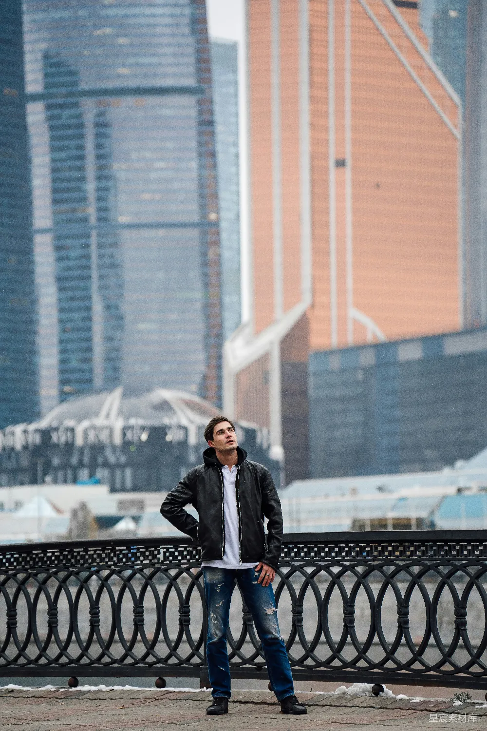 高清摄影 一个男子站在篱笆前，双手叉腰。