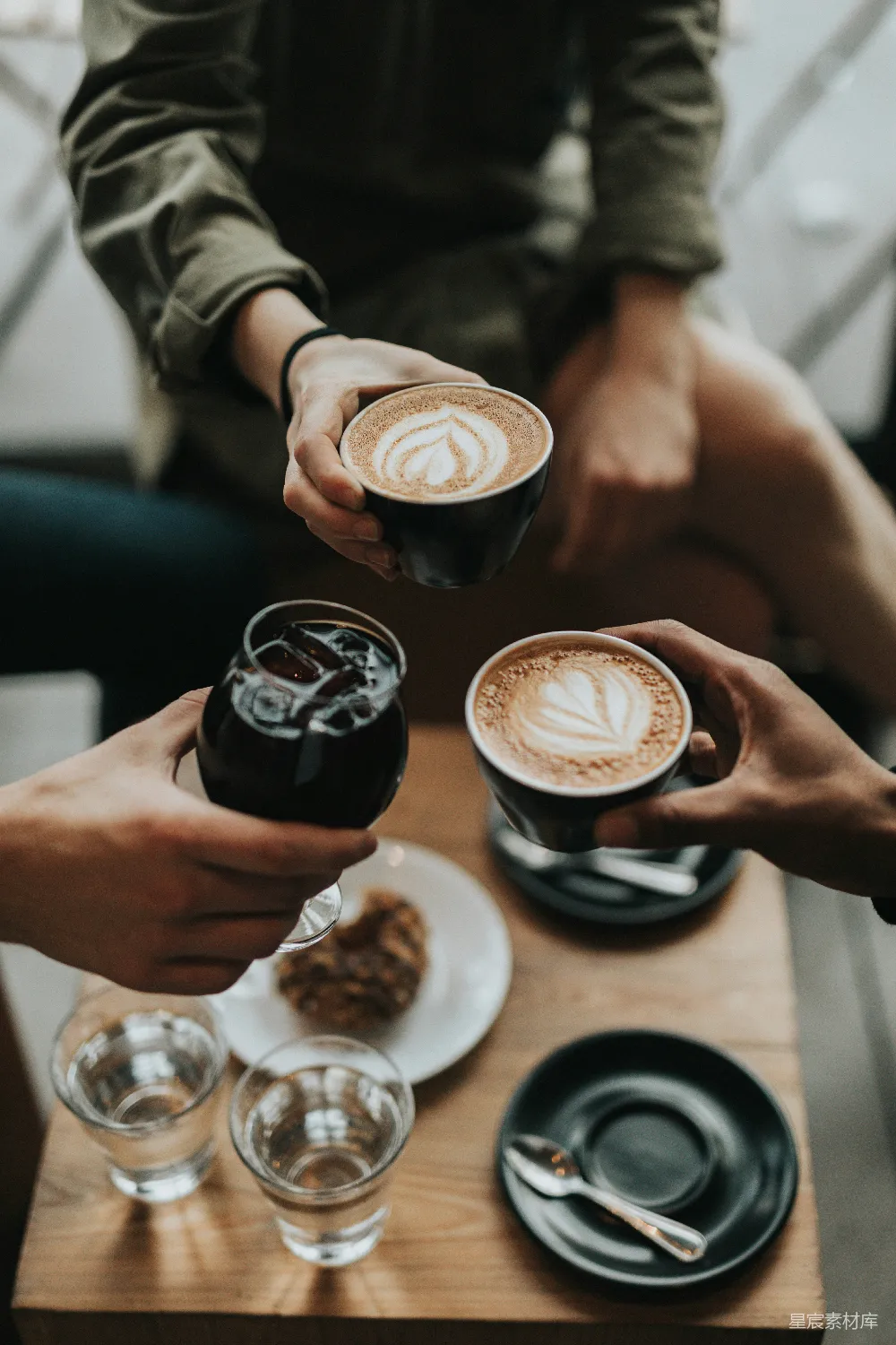 高清摄影 三人手持杯和玻璃杯，杯中盛有饮料。