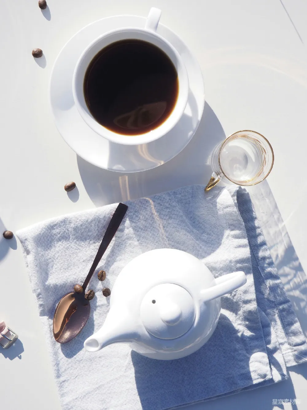 高清摄影 白色陶瓷茶杯里装满了咖啡，放在白色陶瓷托盘上，旁边是一只陶瓷茶壶。