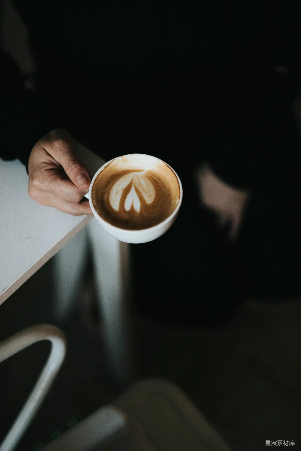 高清摄影  手持白色陶瓷杯的人手中握着一杯棕色液体