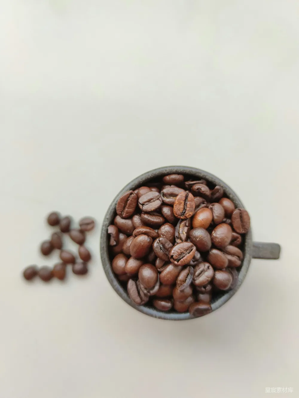 高清摄影  棕色咖啡豆放在黑色陶瓷杯中