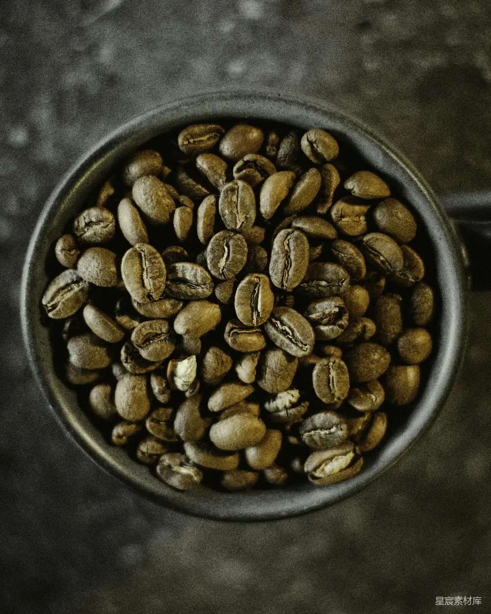 高清摄影  桌子上放着一个盛满咖啡豆的杯子。