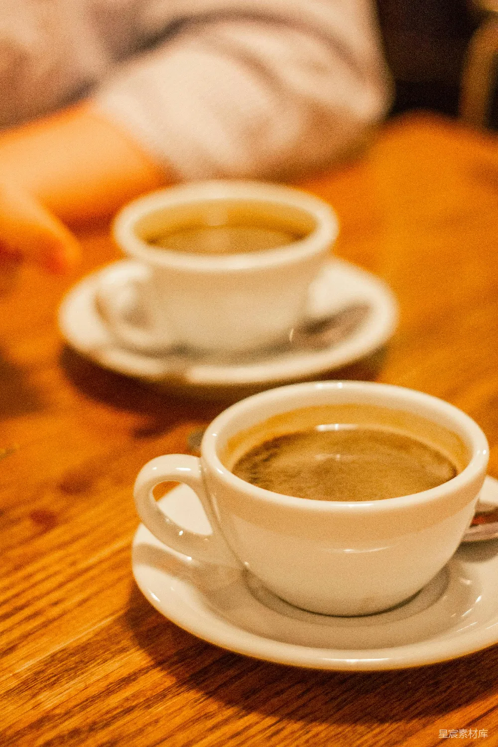 高清摄影  两只杯子放在一张木桌上。