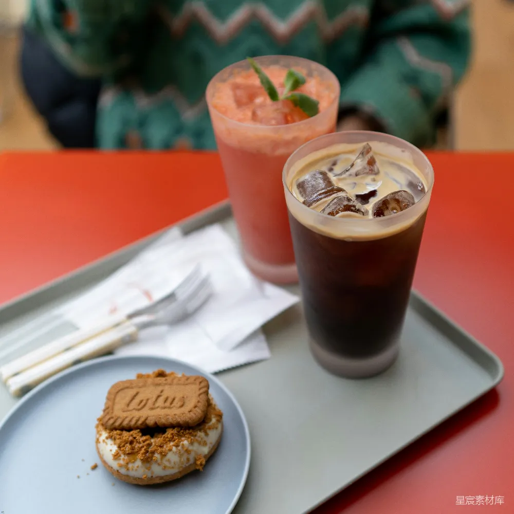 高清摄影  一个托盘上放着两杯饮料和一个甜甜圈。