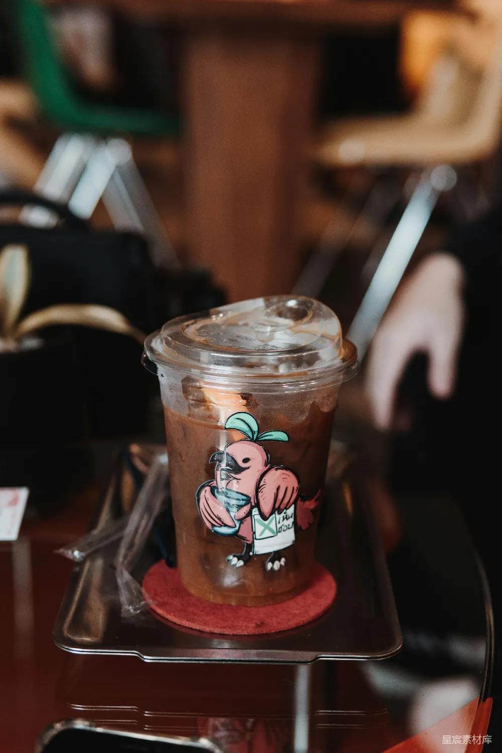 高清摄影  塑料杯中盛放的冰咖啡，上面贴着卡通鸟图案