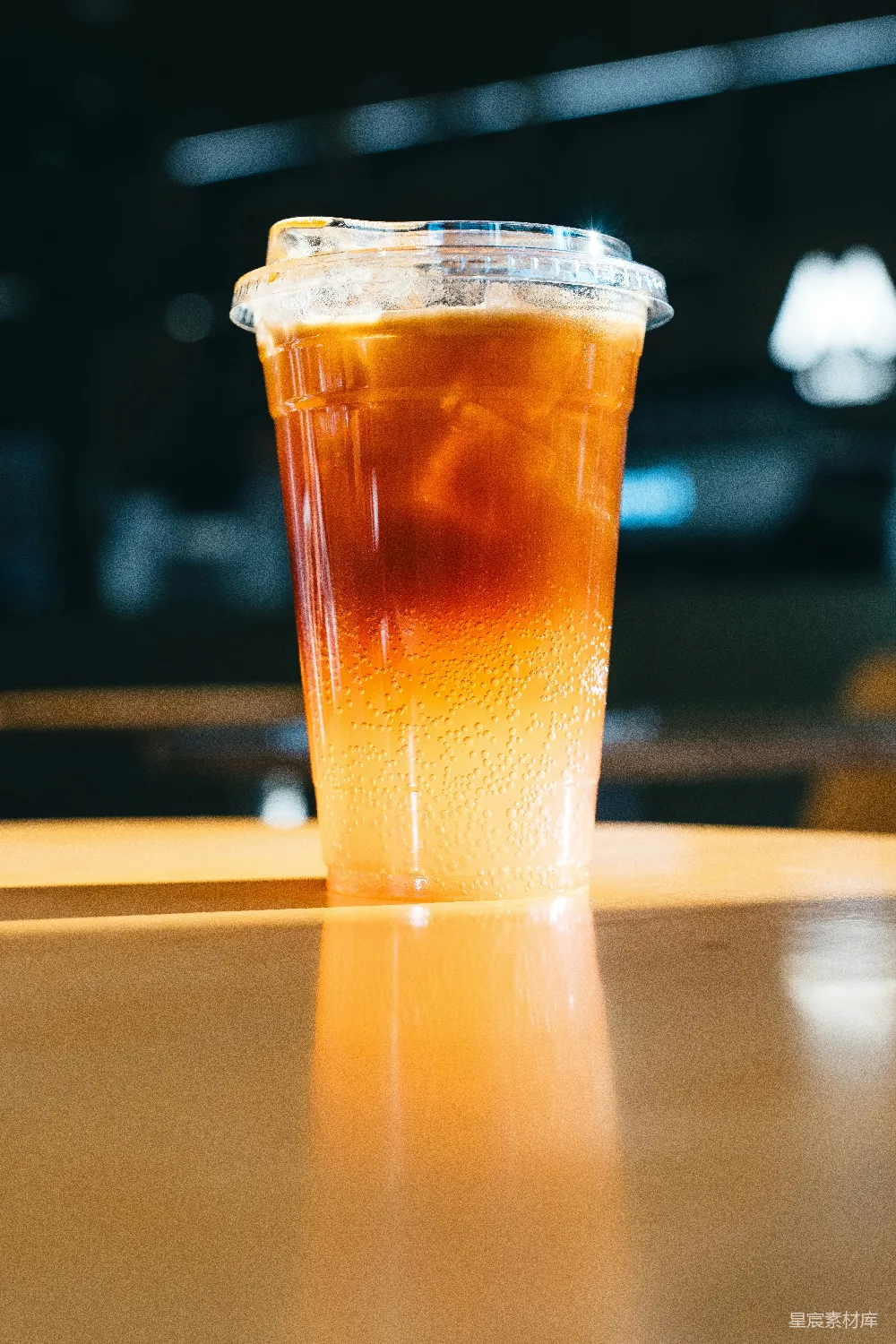 高清摄影 一款 layered 冰咖啡饮料，装在透明塑料杯中。
