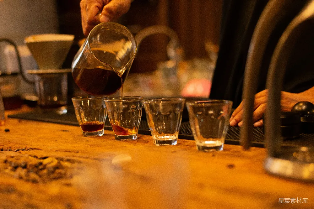 高清摄影  从法式压壶中沥出咖啡倒入小品尝玻璃杯。
