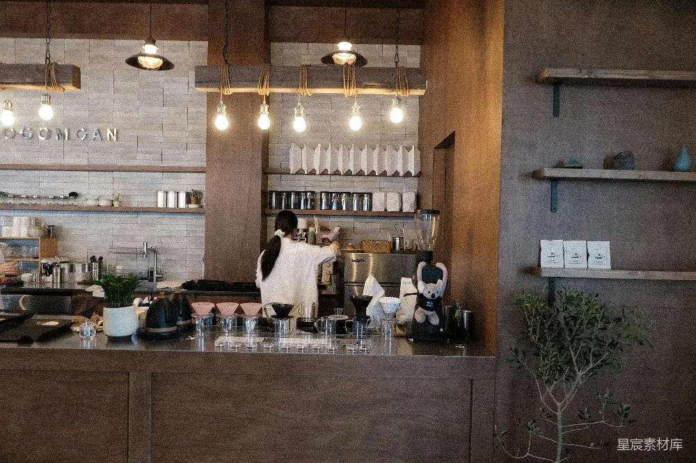 高清摄影 咖啡店柜台后，barista正在准备饮品。
