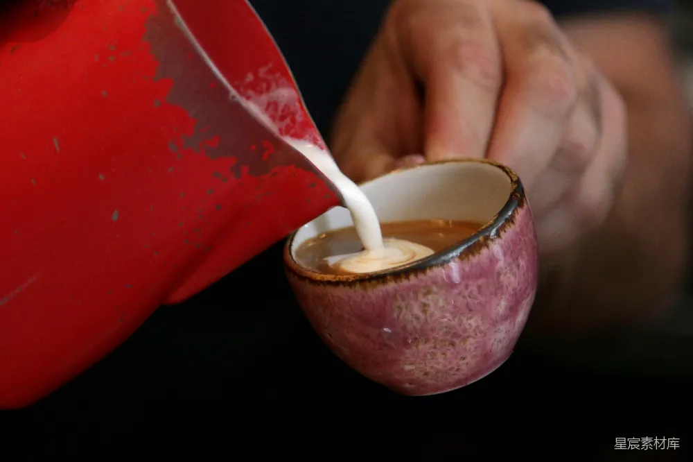 高清摄影 一个人将牛奶倒入一个红色的杯子中