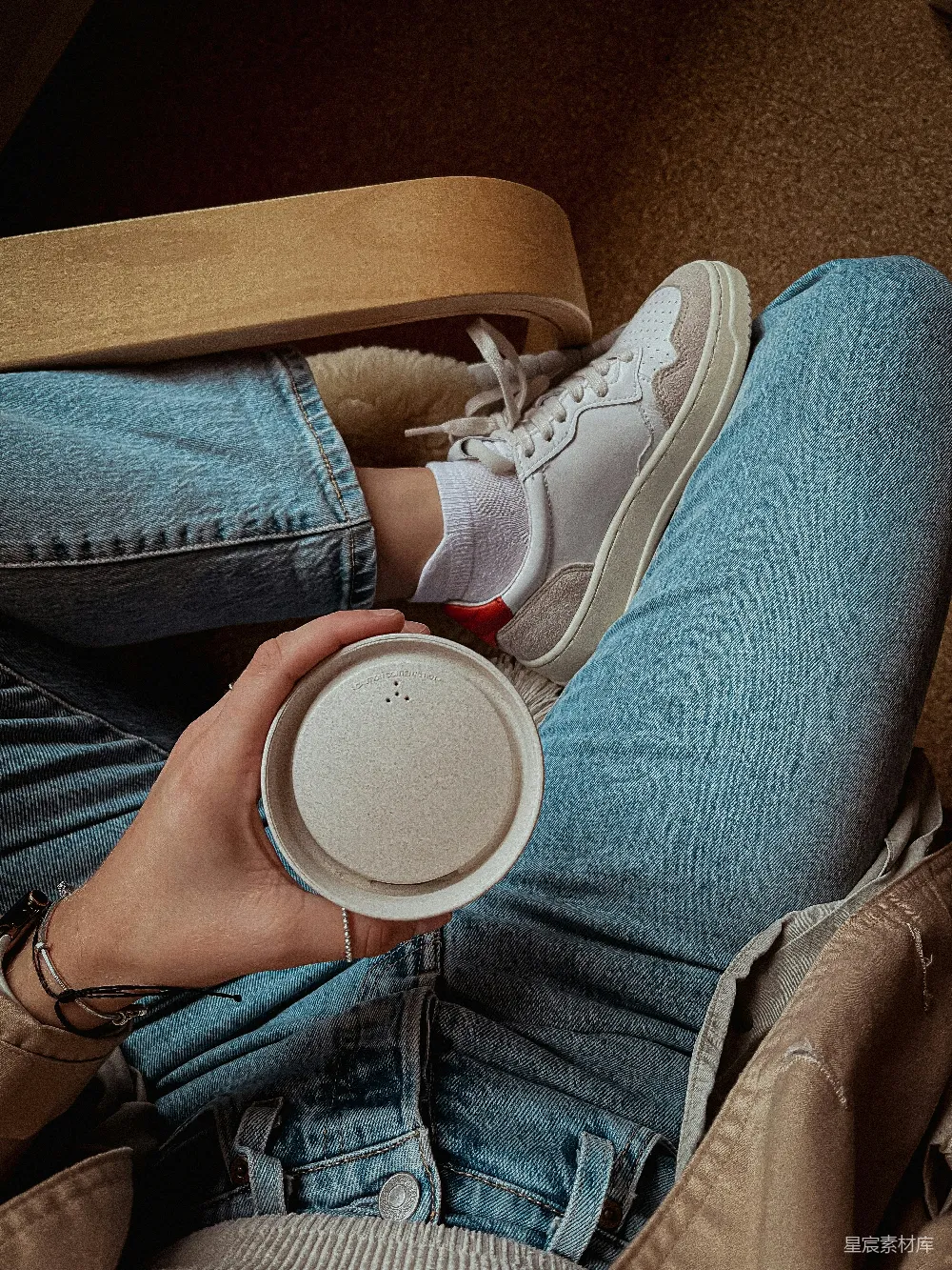 高清摄影  一个坐在地上的人员正在拿着一杯咖啡。