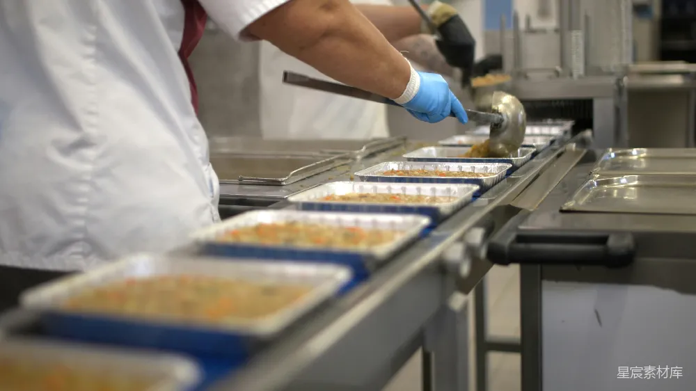 高清摄影  工人正在传送带上填装食品托盘。