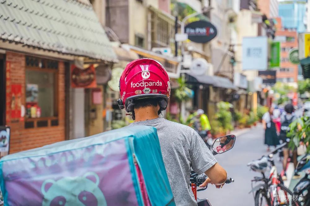 高清摄影 一名男子骑自行车在高建筑物旁的街道上行驶