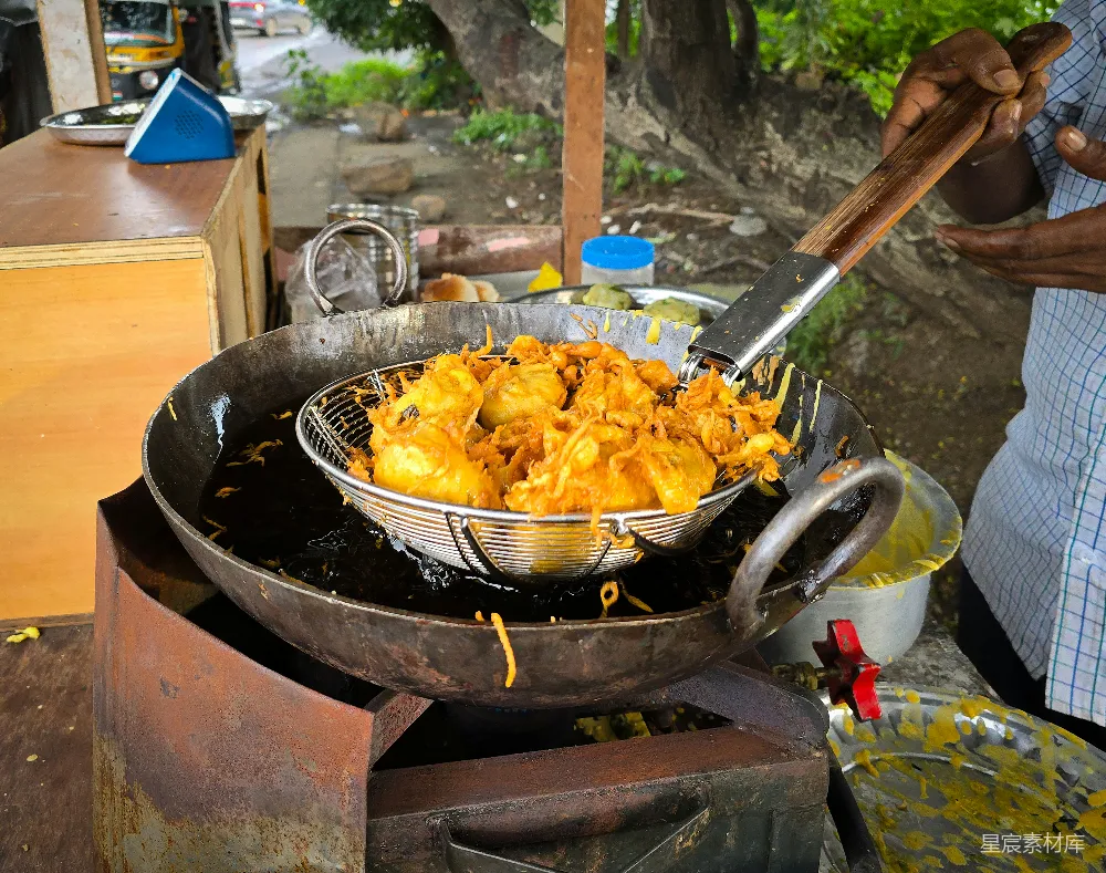 高清摄影 在街边小摊上用大铁锅煎炸 pakoras。