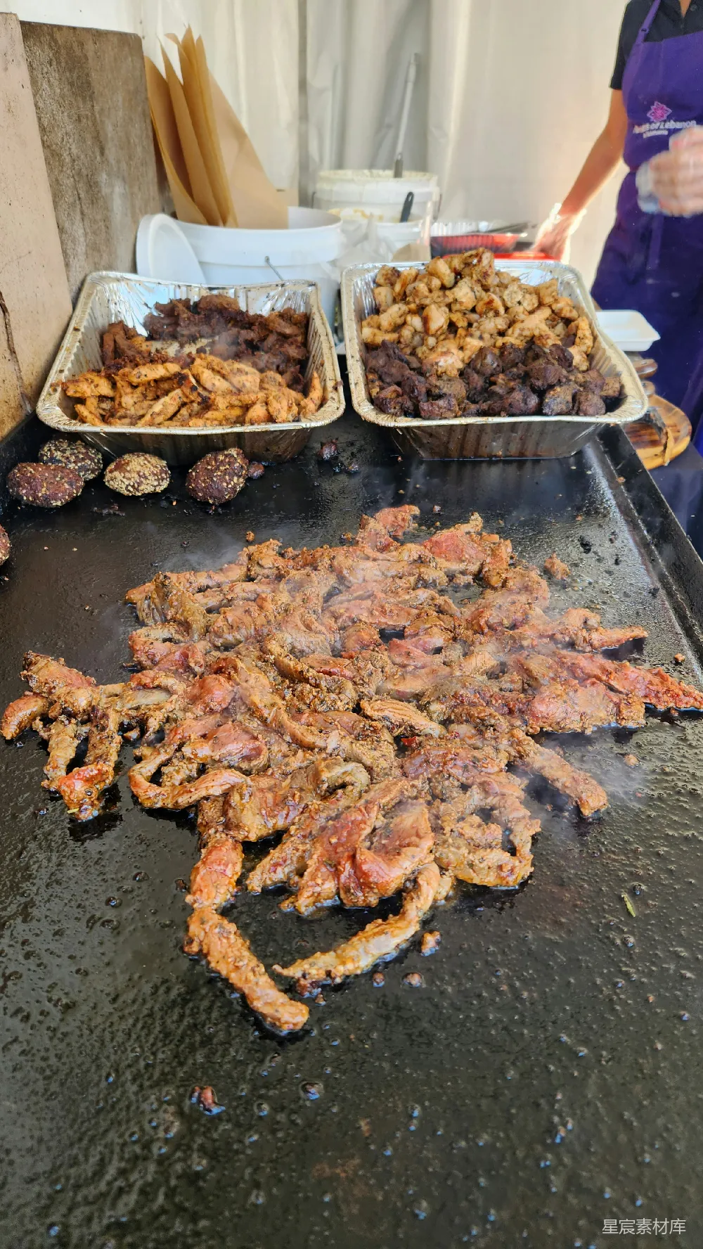 高清摄影 一张桌子上面放着装有食物的托盘，食物上覆盖着肉。