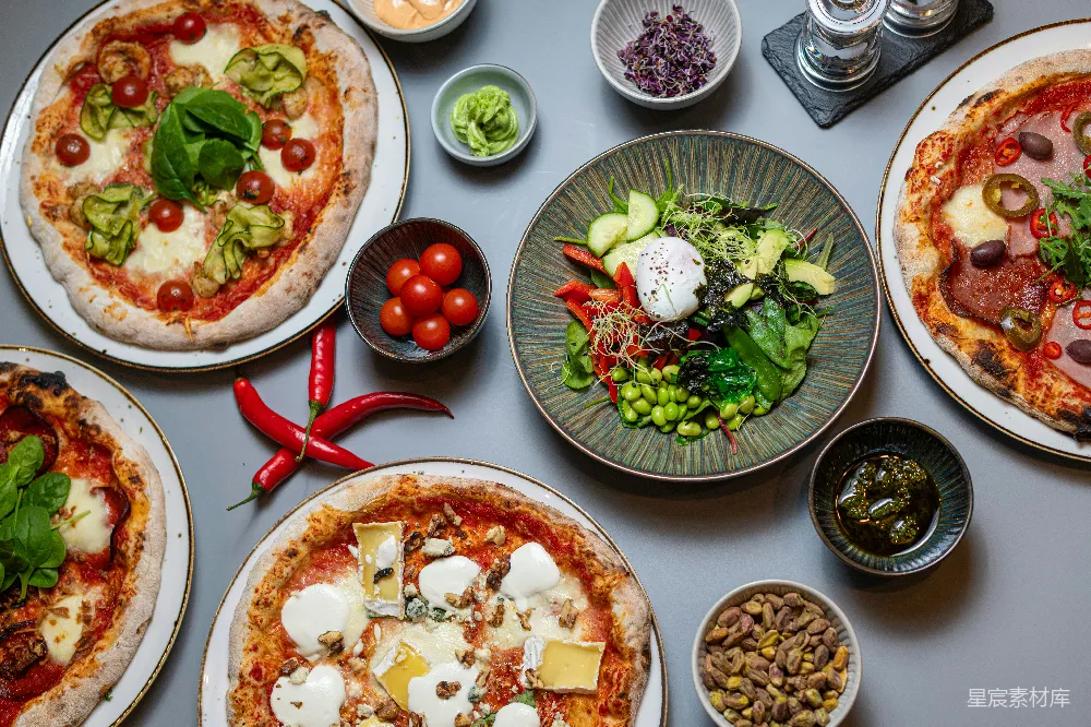 高清摄影  一张桌子上摆满了各种类型的比萨 pizza