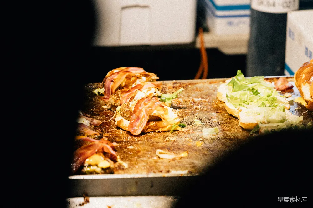 高清摄影 汉堡肉饼在平底锅中烹饪，配有配料。