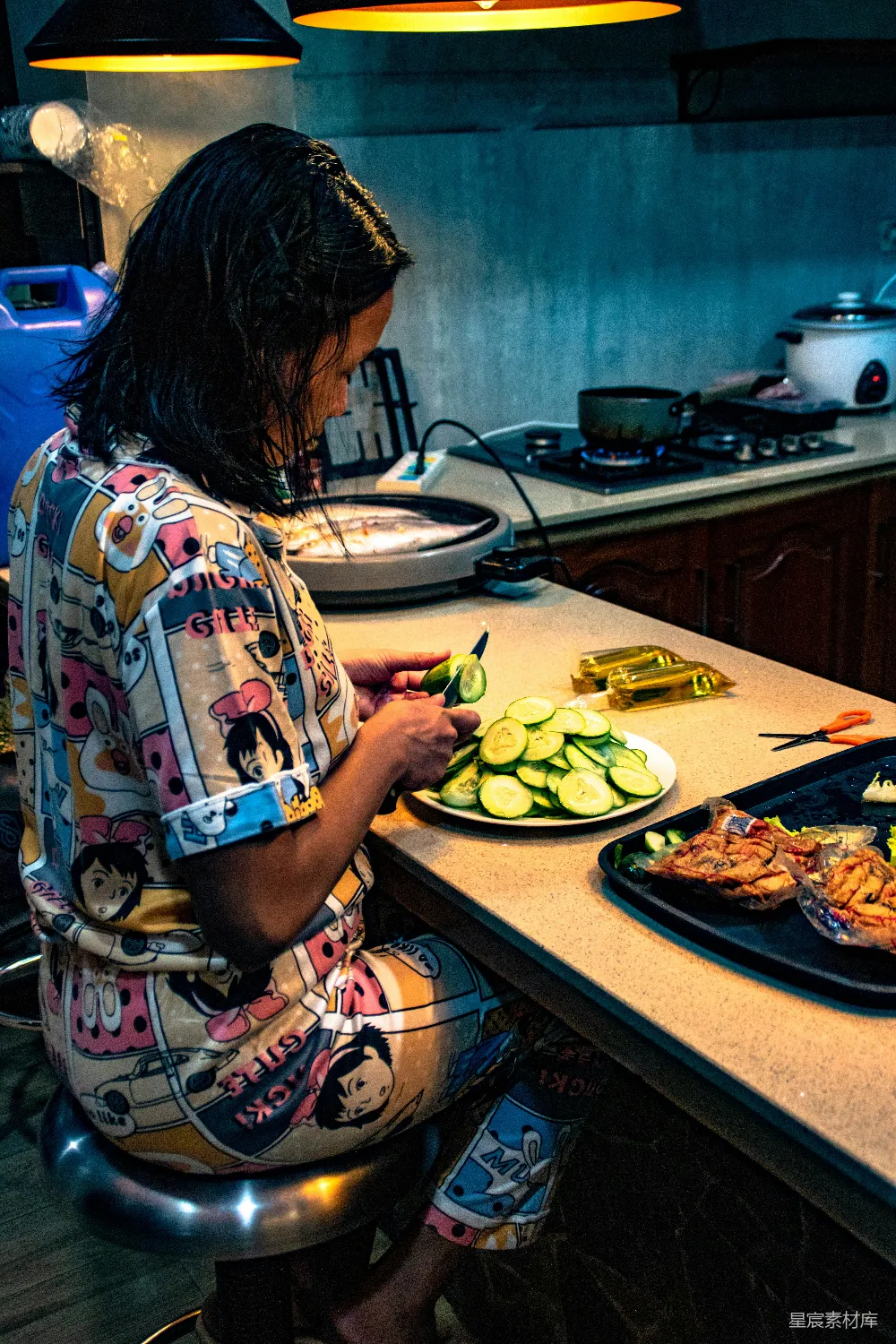 高清摄影  一个女人坐在厨房台面上正在切食物。