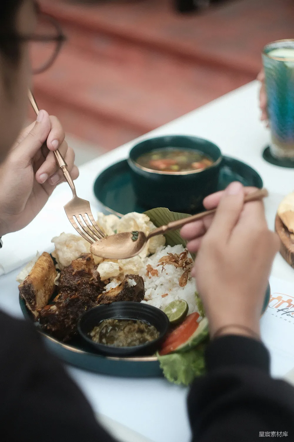 高清摄影 一个坐在桌子旁的人手里拿着一份餐食。