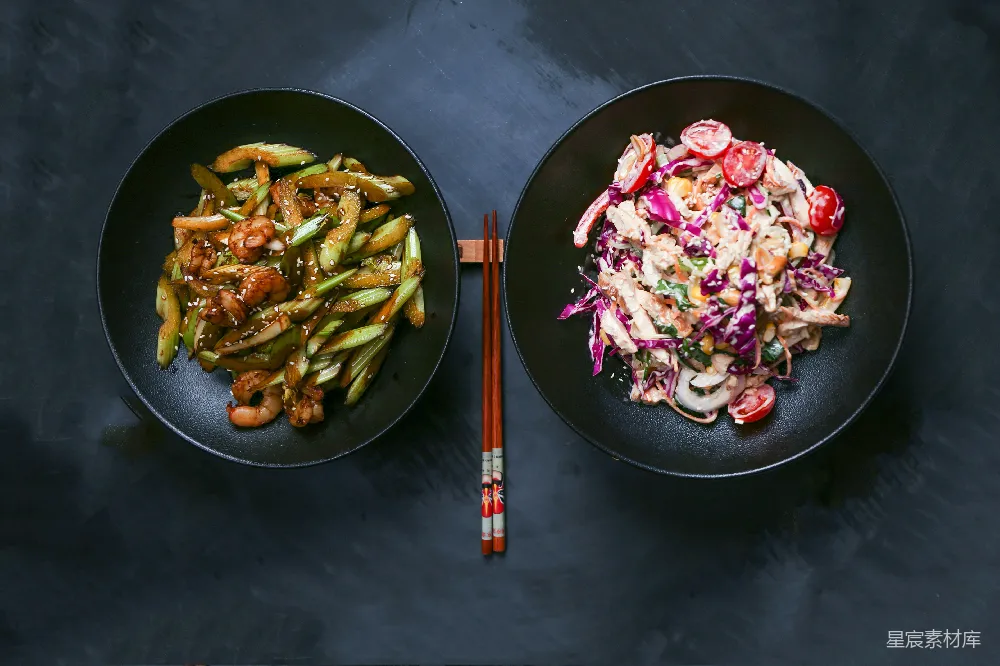 高清摄影 几块黑色的 plates 上放满了食物，放在一张桌子上。
