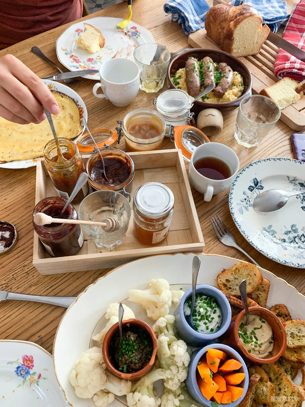 巴黎的法式 brunch（早餐），木质桌面上摆放着许多甜品和咸食。