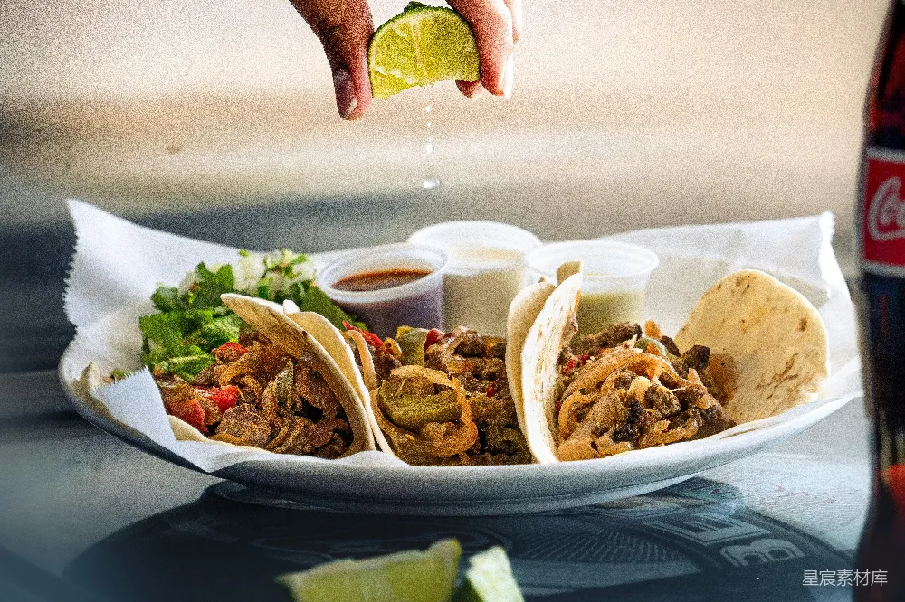 高清摄影  topped with drizzled lime on a plate of tacos