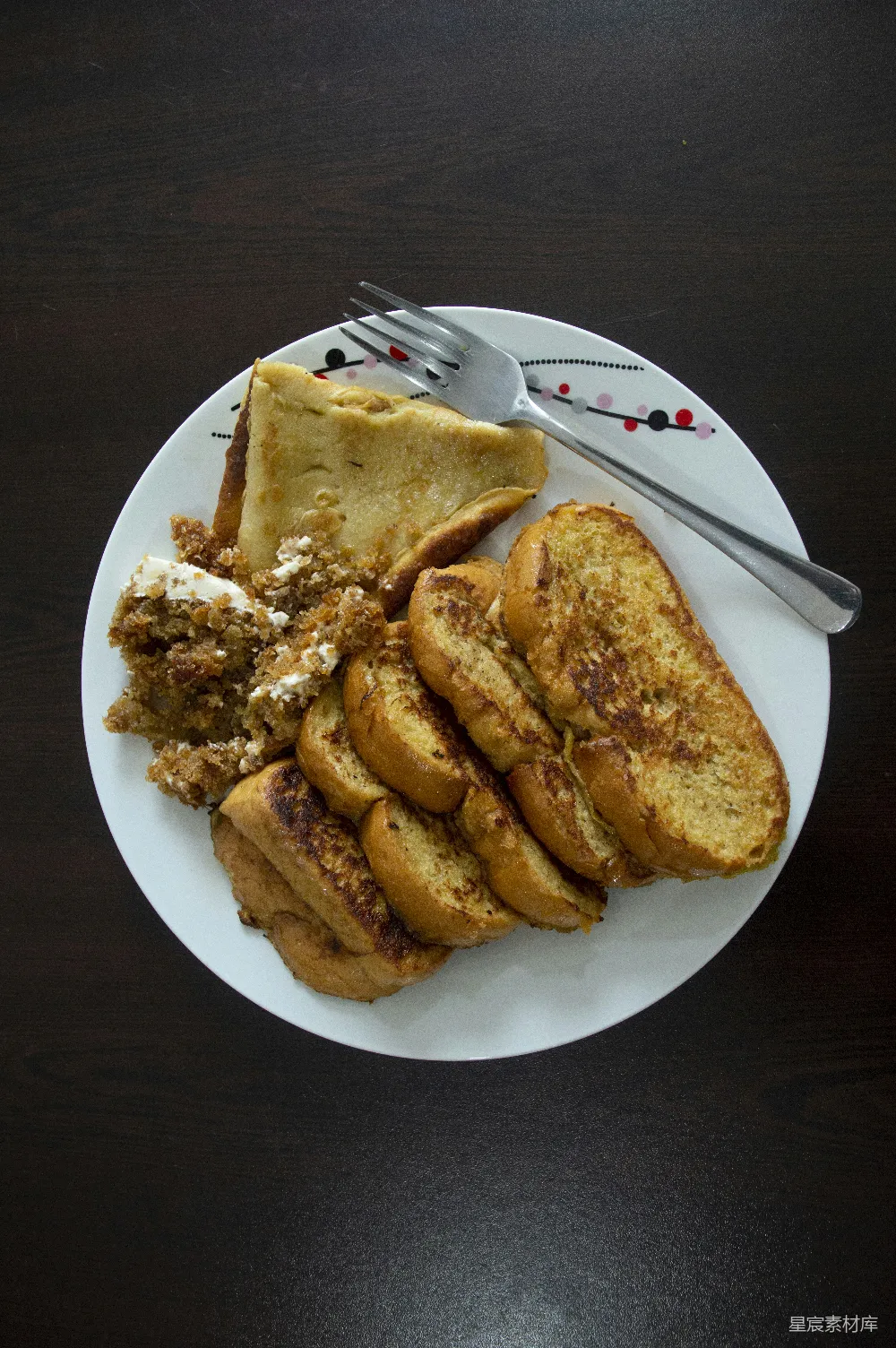 高清摄影  桌子上放着一盘食物，旁边有叉子和刀。