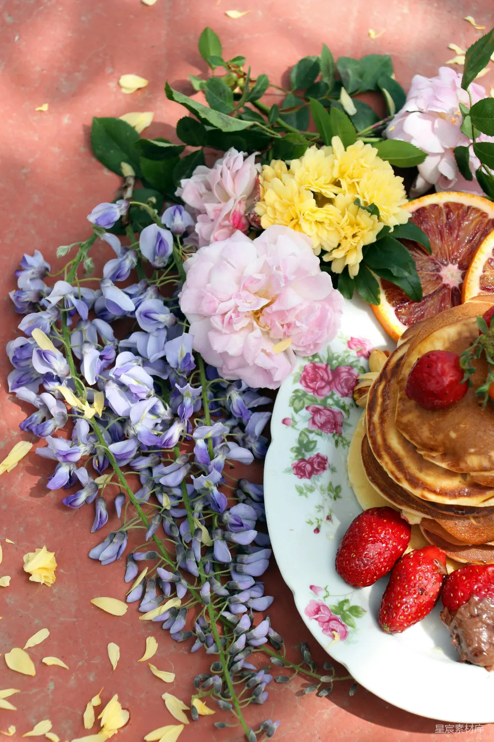 高清摄影  一张桌子上有 Pancakes、草莓和花朵的盘子