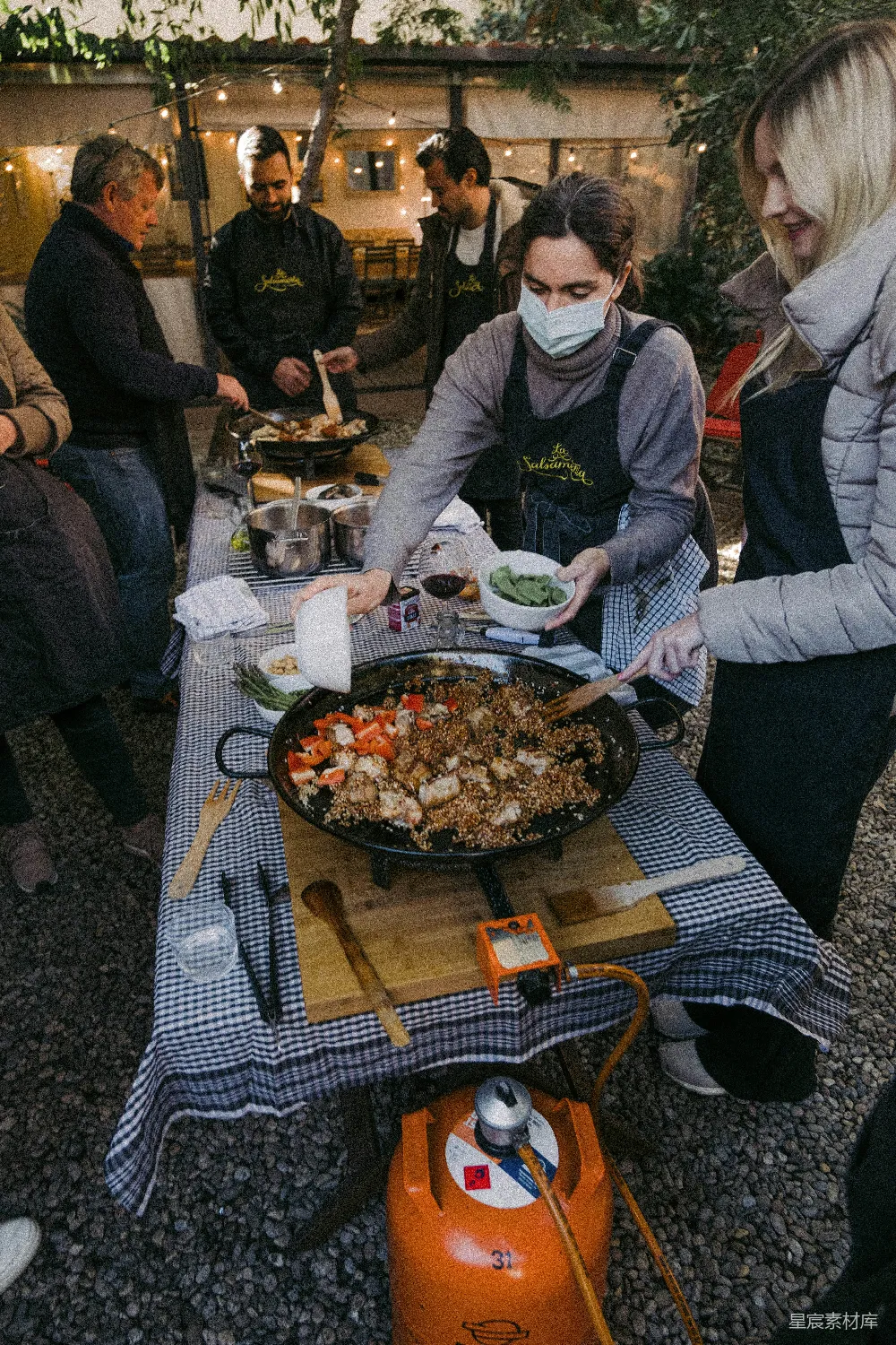 高清摄影  一群人围坐在一张桌子旁，桌子上有食物。