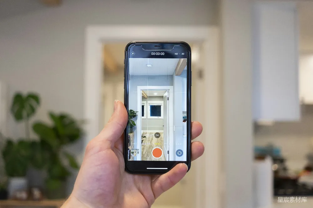高清摄影  手持银色iPhone 6的人正在拍摄一座白色的混凝土建筑。
