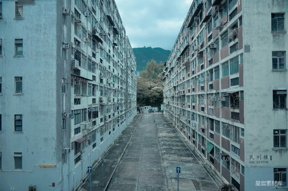 高清摄影  街道两栋建筑之间的空地，背景是山。