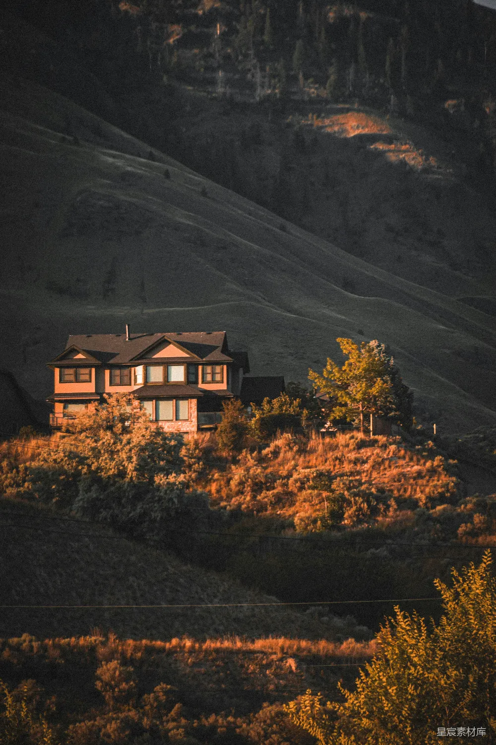 高清摄影  夕阳西下，一座房子坐落在小山上。