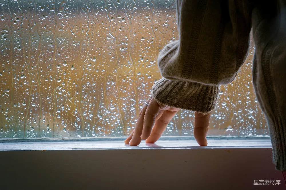 站在雨中的窗台上的人