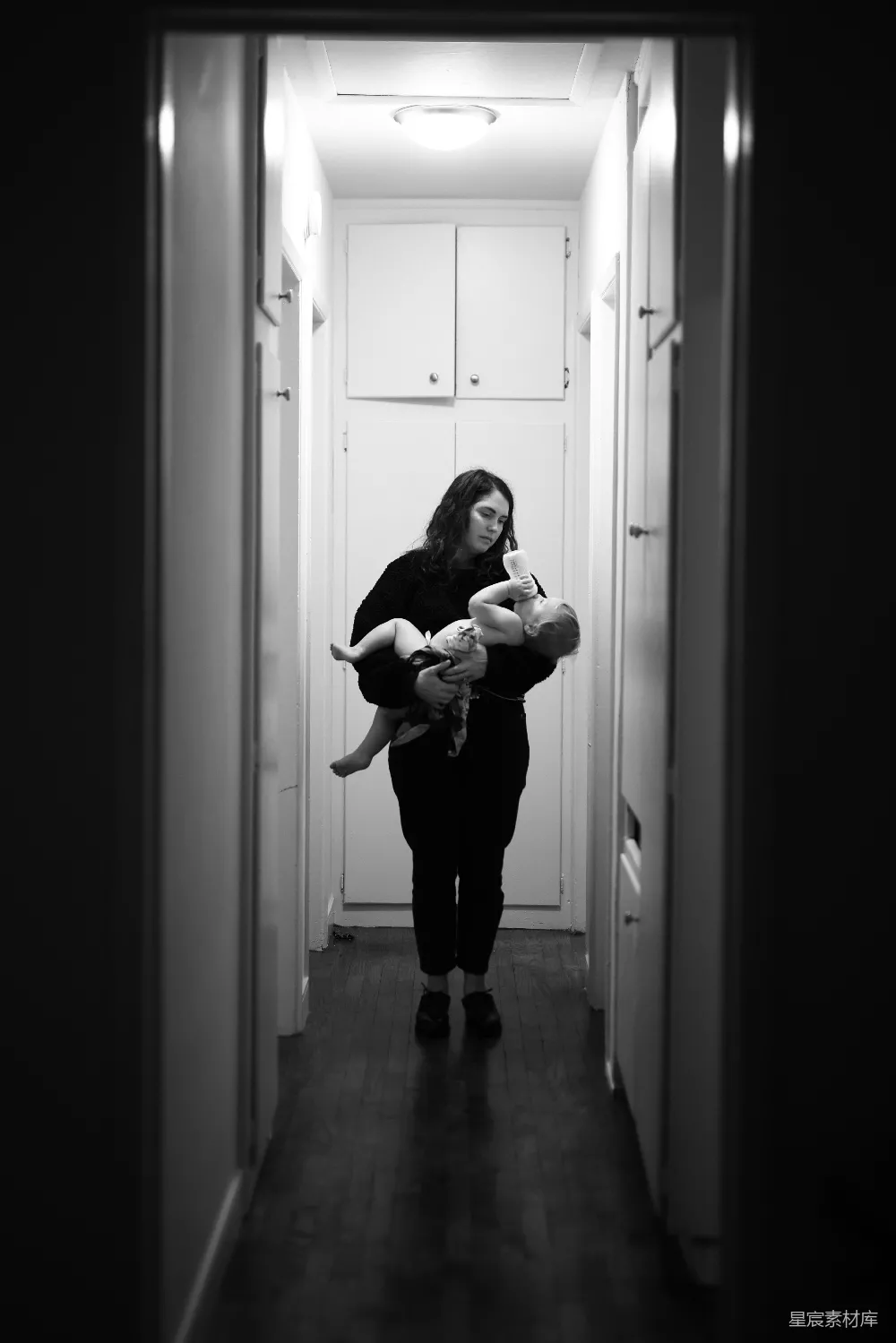 高清摄影 穿着黑色长袖衬衫的女人抱着孩子，这是黑白照片。