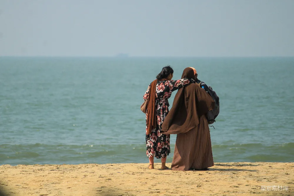 高清摄影 人物 两个女人站在沙质海滩上。
