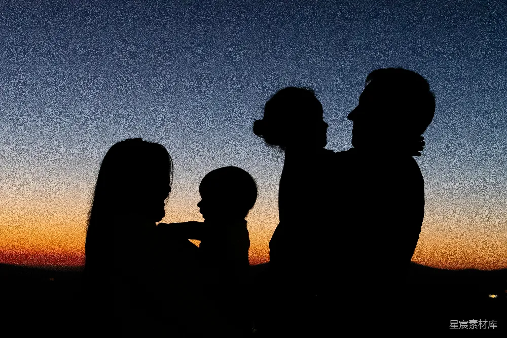 高清摄影  夕阳下，两位女士和一位男士并肩站立的剪影。