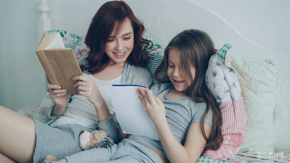 细心的母亲正在帮助她的小可爱女儿完成小学作业。关爱的妈妈在阅读一本书，而女孩在笔记本上做笔记，她们一起坐在温馨的卧室里。