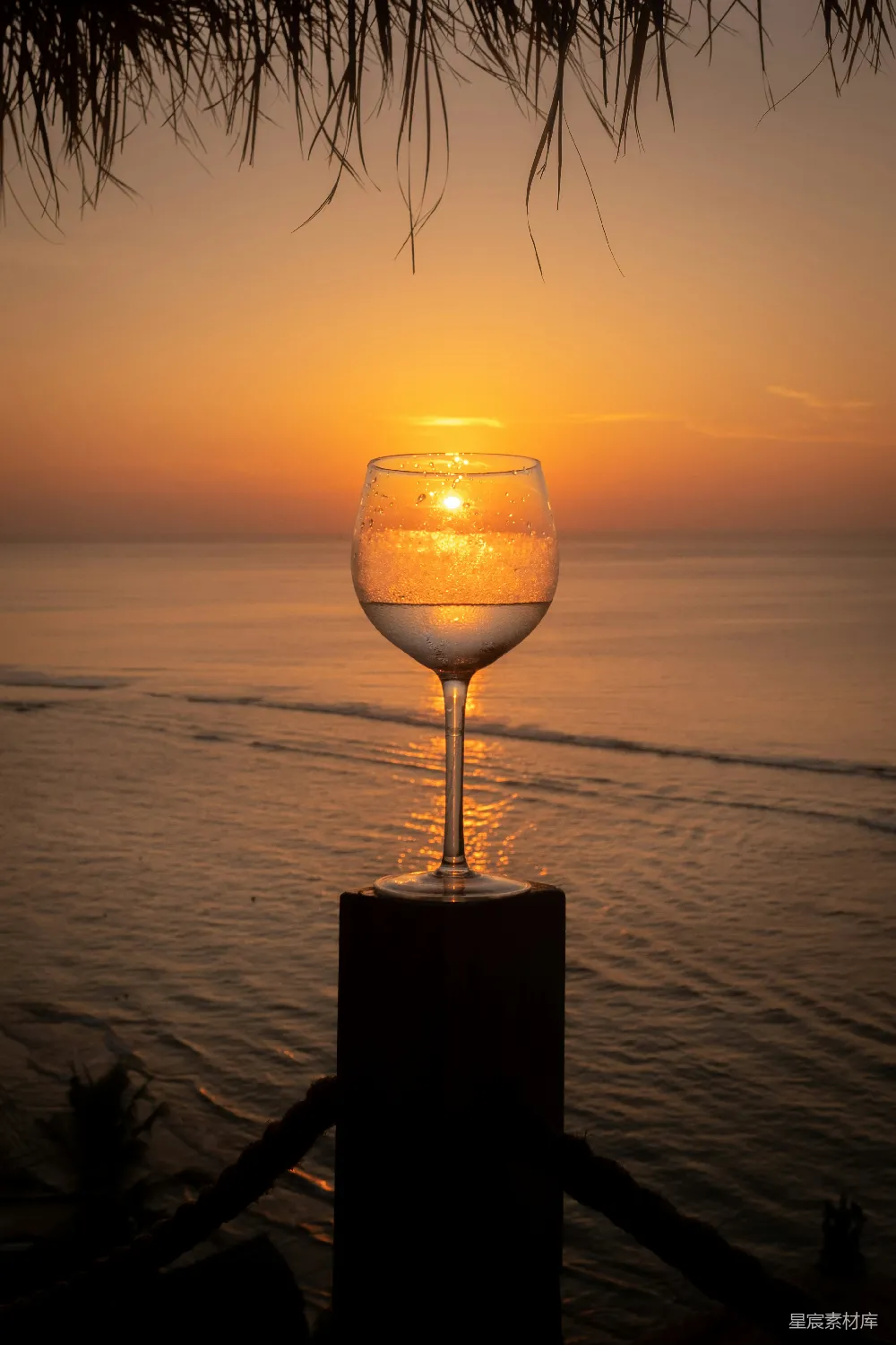 夕阳西下时，在棕色木桌上清除一个酒杯。