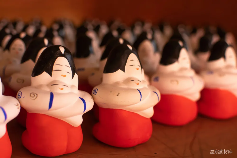 高清摄影  一排小陶瓷雕像放在桌子上面。