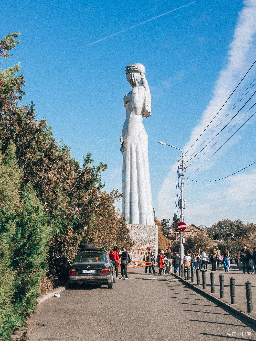 高清摄影  一群人围着一座巨大的白色雕像站着。