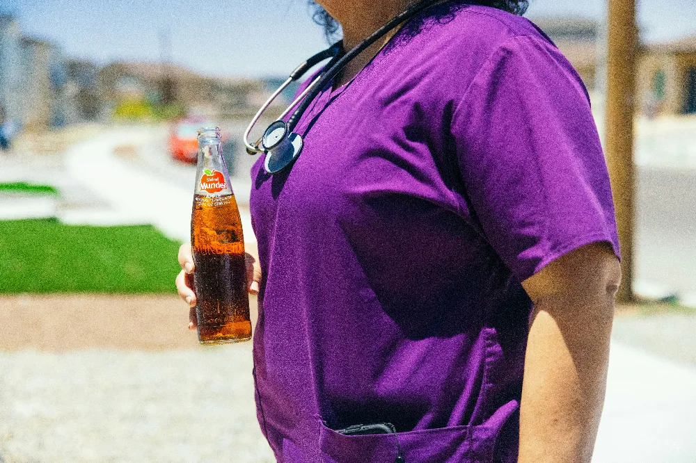 高清摄影  一个戴着听诊器的女人手里拿着一瓶啤酒。