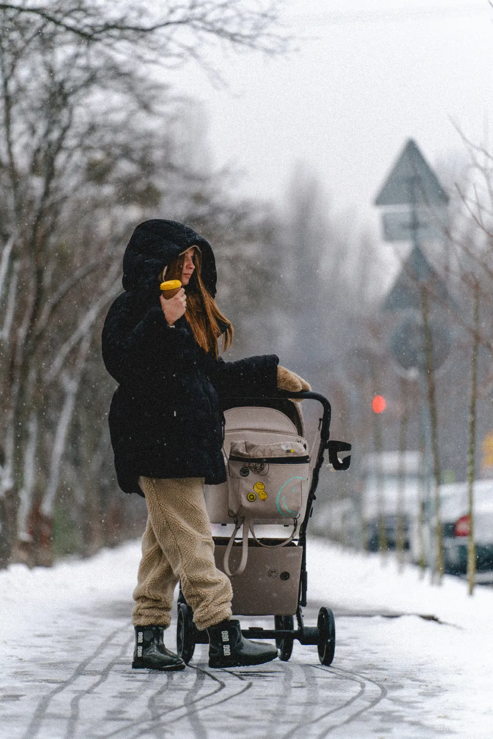 高清摄影  一个女人推着婴儿车走在积雪覆盖的街道上