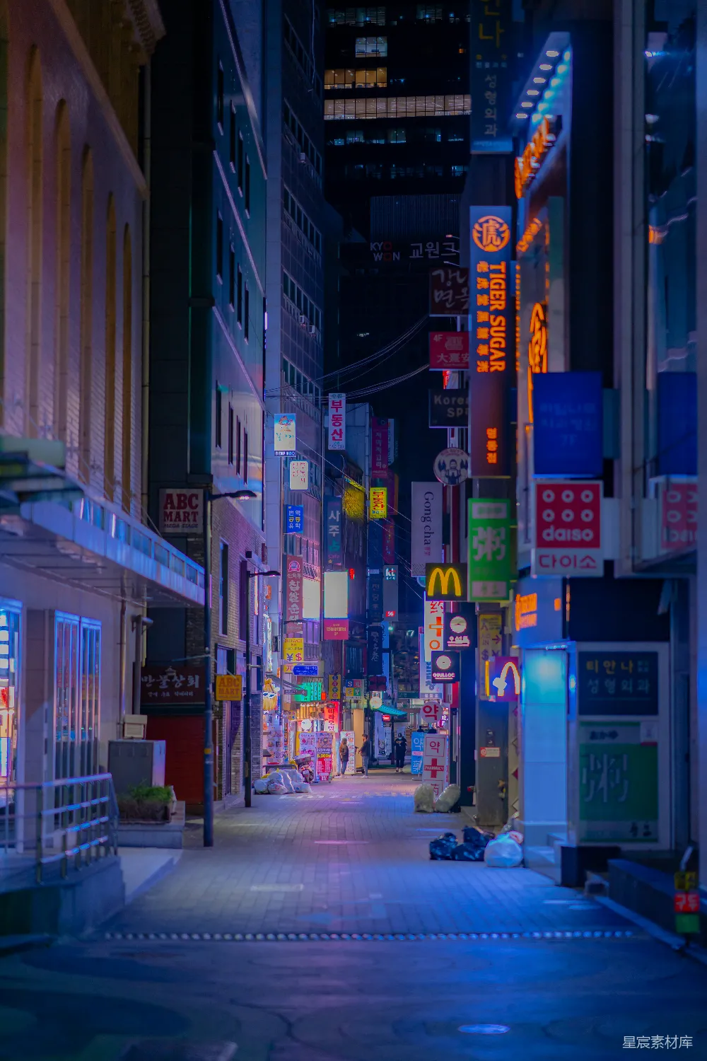 高清摄影  夜间，建筑物附近的人行道上行走的人们