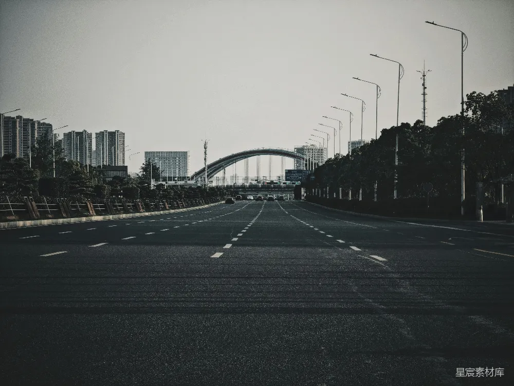 高清摄影  一条空旷的街道，背景中有一座桥。