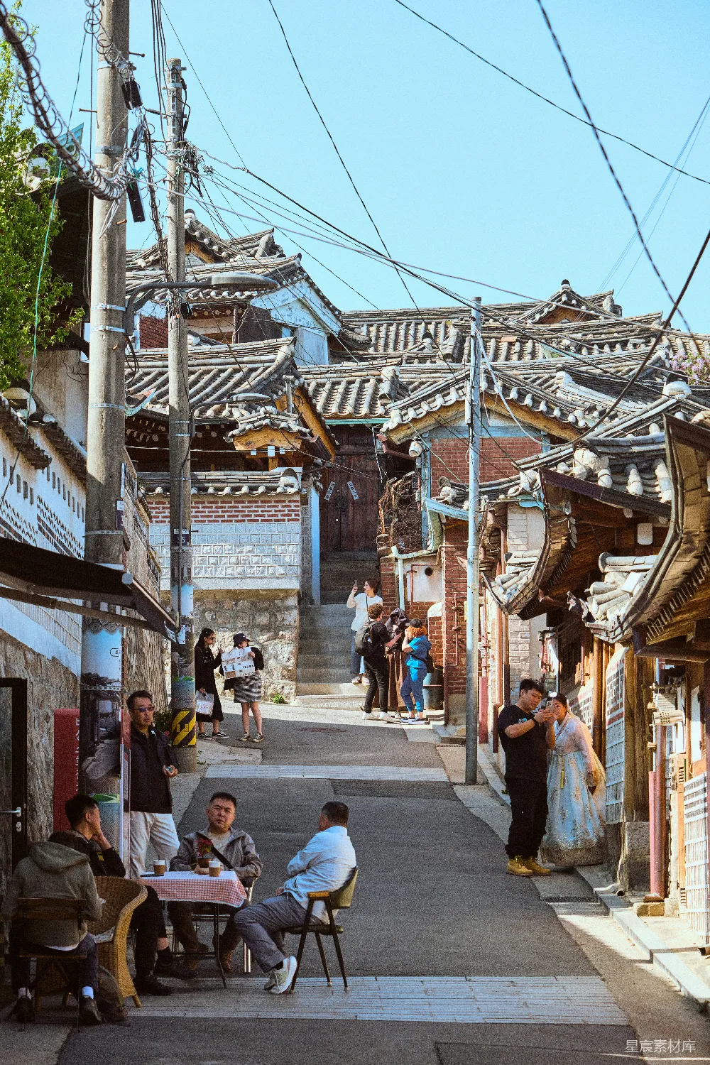 高清摄影 人物 旅行 电影 一群人在人行道上的桌子旁坐着。
