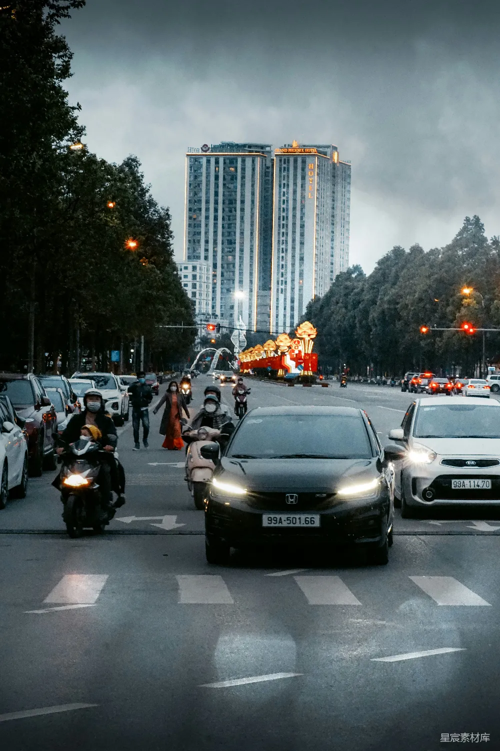 高清摄影  一排汽车沿着街边高楼大厦行驶。