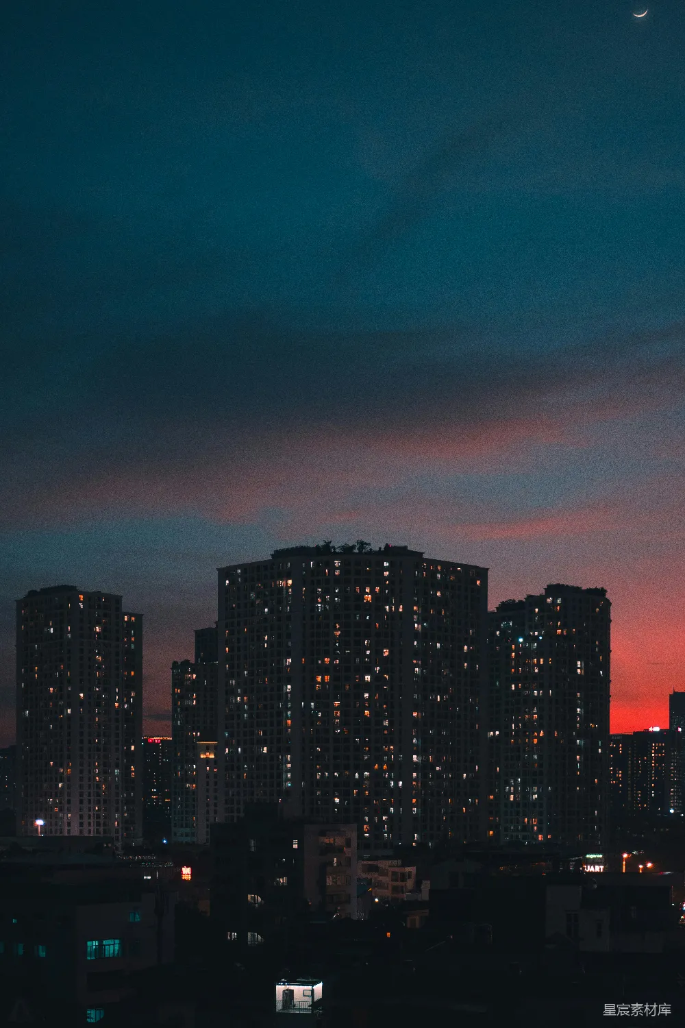 高清摄影  夜晚的城市天际线，月亮高悬在空中
