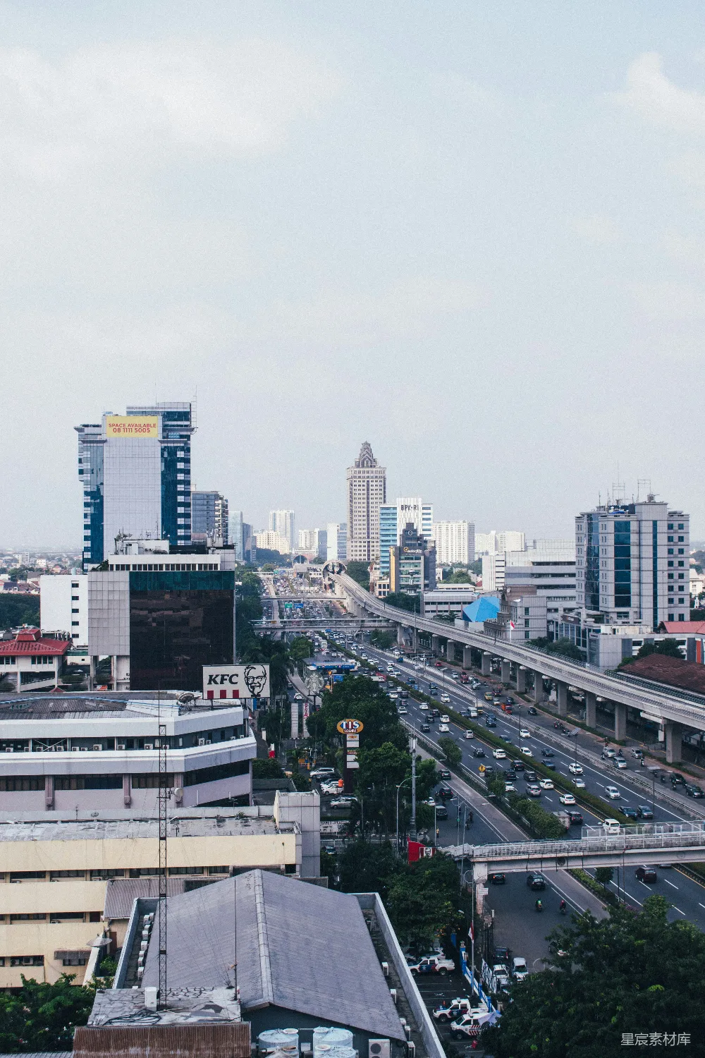 高清摄影  白天城市建筑附近的路上有汽车。